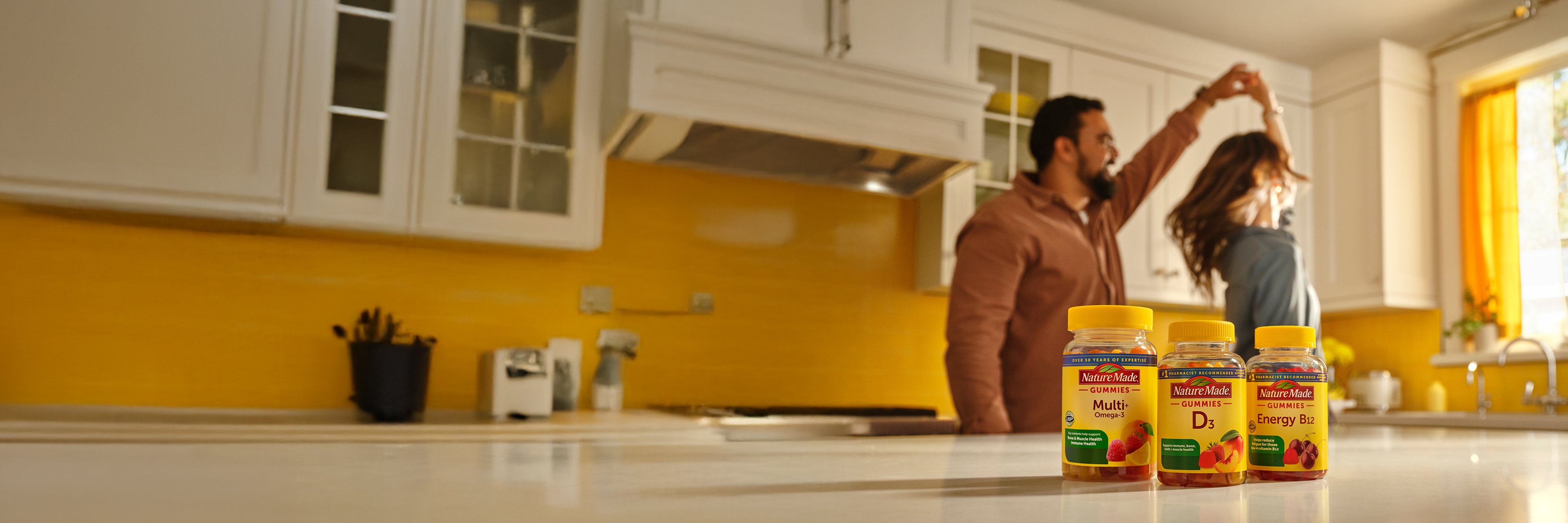 Nature Made Gummies on the Counter with family dancing behind