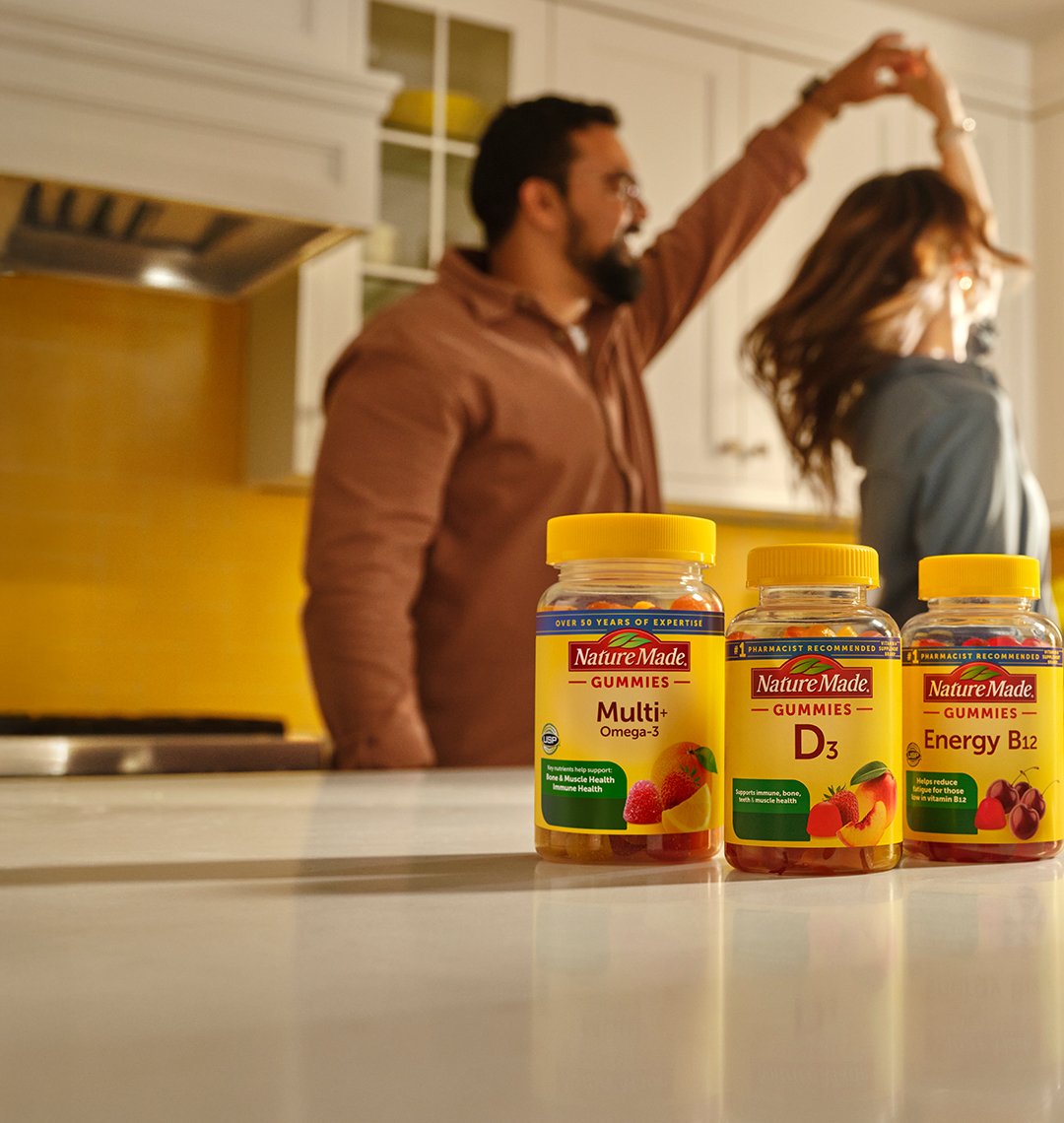 Nature Made Gummies on the Counter with family dancing behind